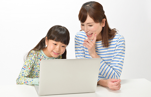 親子でパソコンを見る写真